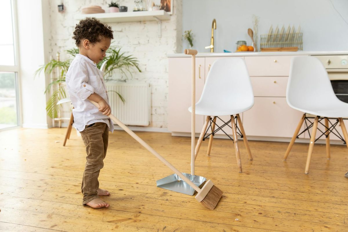 little kid sweeping floor