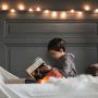 boy in gray jacket reading book