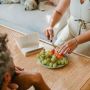 crop pregnant woman cutting fruit for husband