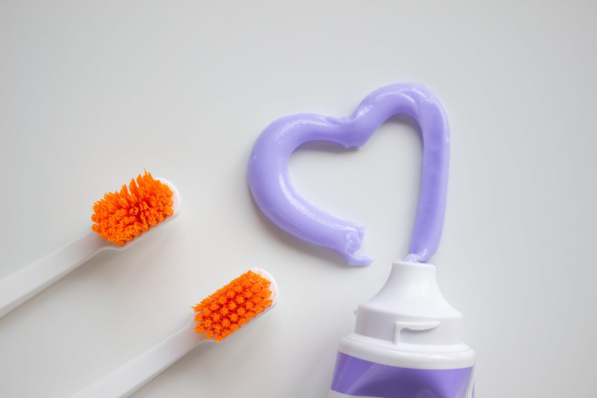 a toothbrushes and toothpaste on a white surface