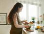 a pregnant woman preparing food on the kitchen counter