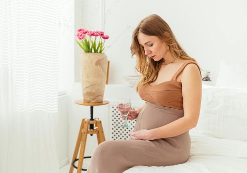 a pregnant woman staring at her baby bump